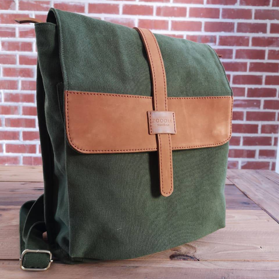 Front angled view of Zoodle Laptop Backpack in green canvas and tan leather, perfect for urban travel and laptop storage.