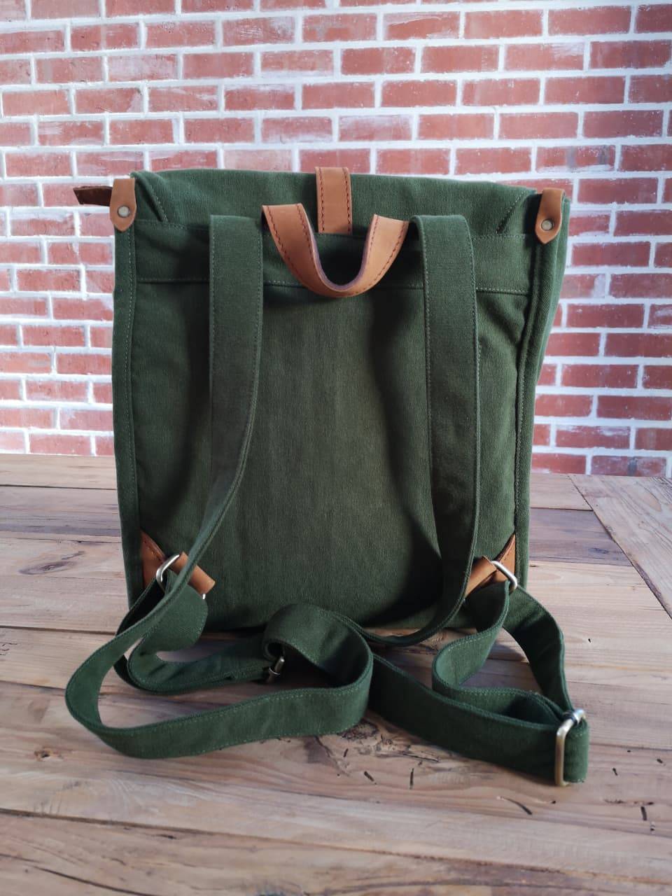Back view of Zoodle Laptop Backpack in green canvas with adjustable straps and leather accents, designed for comfort and style.