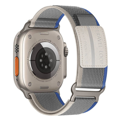 Adventure Strap for Apple Watch in gray and blue nylon with Velcro fastener, designed for rugged outdoor use and compatible with 38-49mm models.