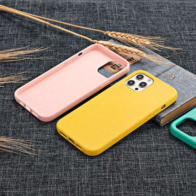 Back view of pink and yellow Eco-Friendly Slimline iPhone Cases on fabric surface, highlighting minimalist design and eco-conscious materials.