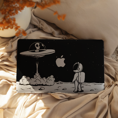 Laptop with a unique design on a bed with pillows and decorative elements
