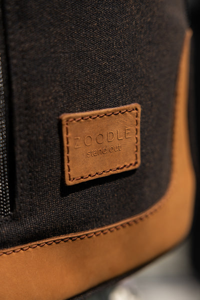 Close-up of a black and brown bag with a visible brand label.