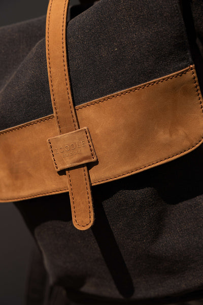 Zoodle Laptop Backpack in 14oz stone wash canvas and premium leather, showcasing front flap detail with stitched Zoodle brand tag. Ideal for urban laptop carry.